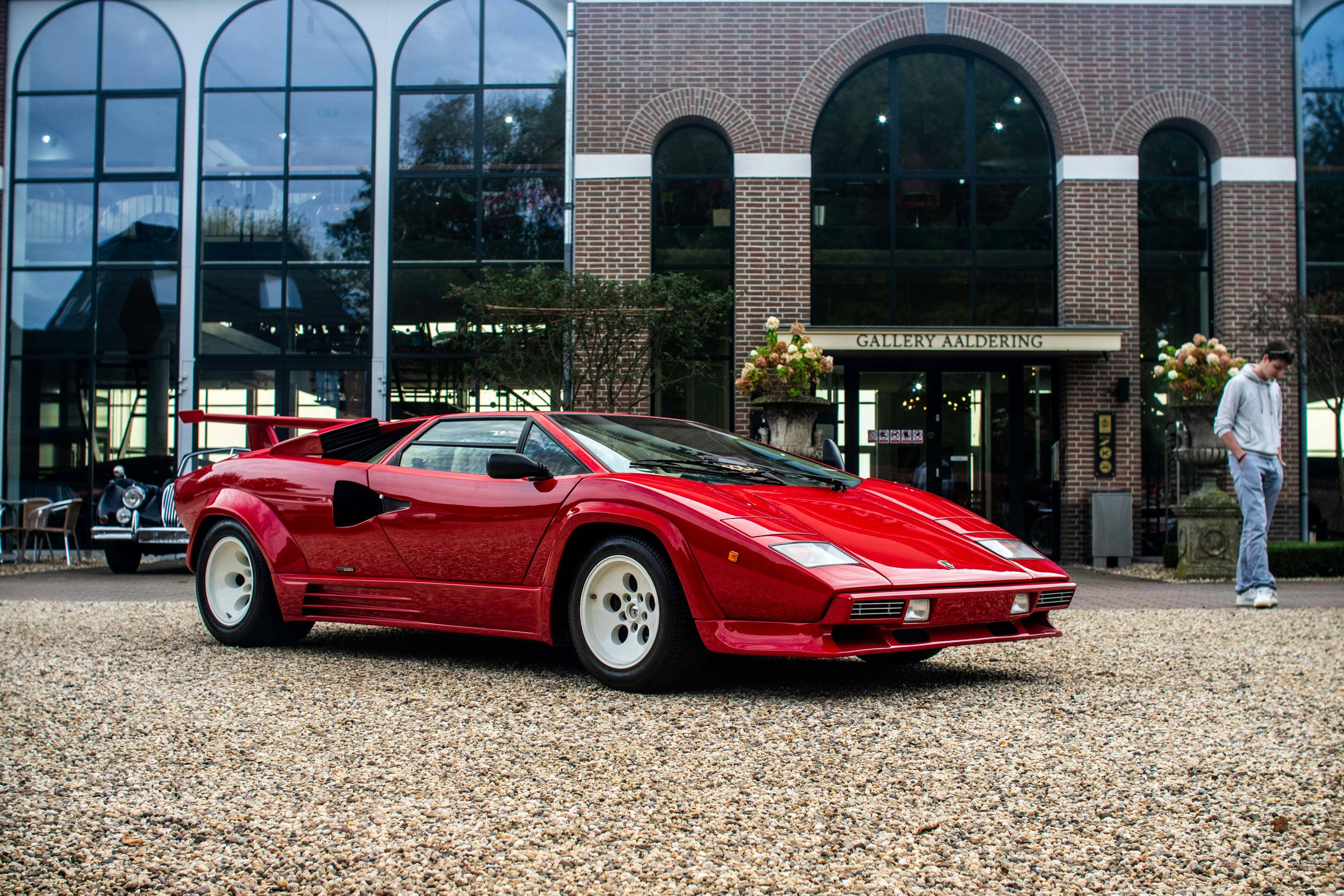 A red sports car parked in front of a building